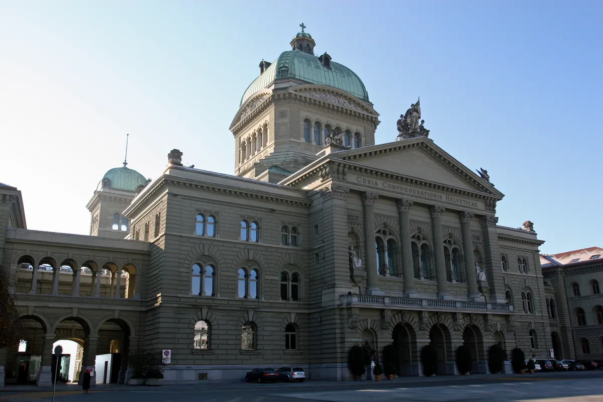 Daytime view of Switzerland’s Federal Palace parliament building in Bern with the inscription Curia Confoederationis Helveticae